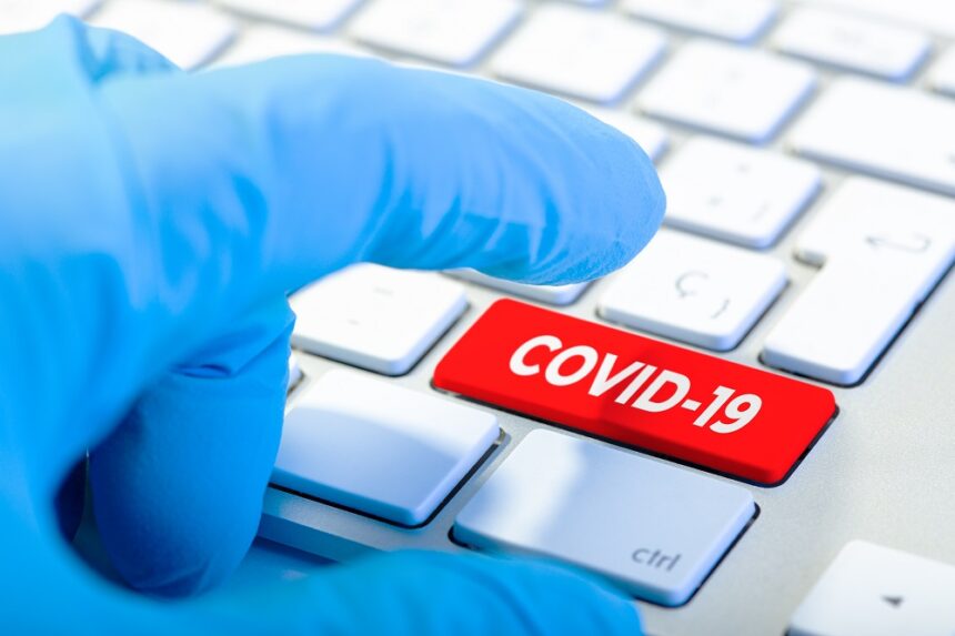 Hand with protecting glove and Keyboard with red key and COVID-19 message. Coronavirus concept Extensión del Mecanismo de Respuesta al COVID-19 y Flexibilidades en las subvenciones